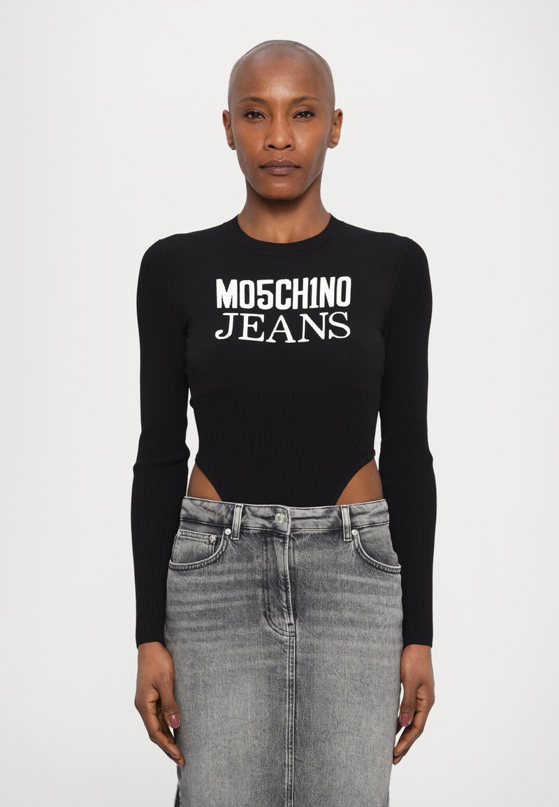 Bodysuit preto com textura canelada e aberturas laterais exibindo o texto branco "MO5CH1NO JEANS"; combinado com uma saia lápis de denim cinza.