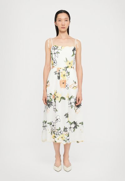 Vestido midi floral con base blanca, flores amarillas y negras bordadas, tirantes ajustables y escote con borde en forma de ondas.