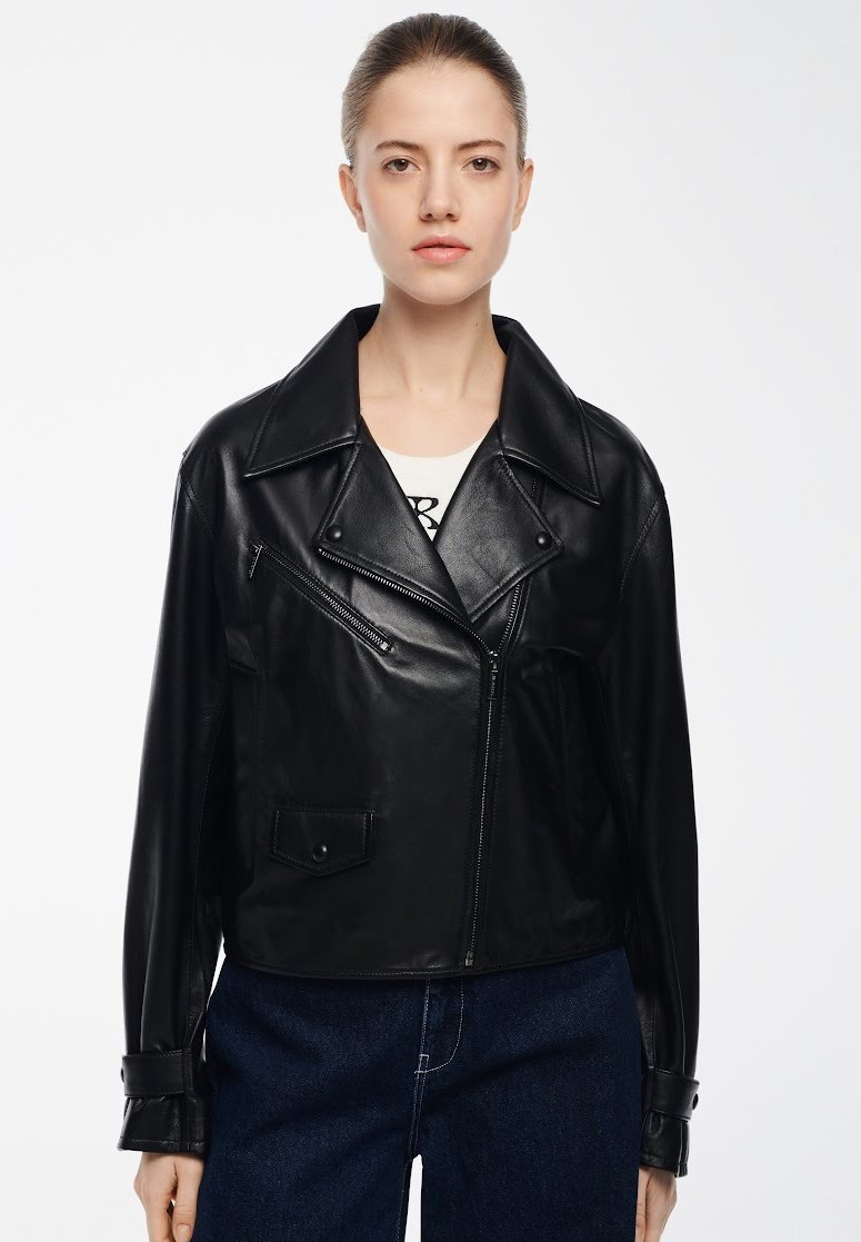 Giacca in pelle nera con colletto a punta, chiusura frontale con zip e tasche laterali; presenta una texture liscia e un design con vestibilità ampia.