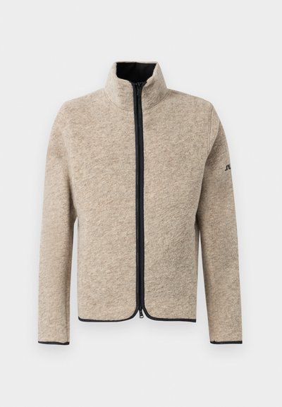 Beige fleece jacket with a high collar, front zipper, and contrasting black trim along the zipper and cuff edges. Smooth texture.