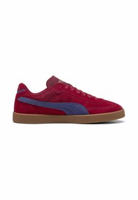 Røde ruskinds sneakers med en lilla accentstripe, flad brun gummisål og klassisk snøredesign. Tekstur overdel med polstret krave.