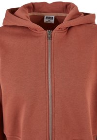 Roodbruine zip-up hoodie gemaakt van zachte stof, met een rits aan de voorkant, verstelbare capuchon en geribbelde manchetten voor een aansluitende pasvorm.