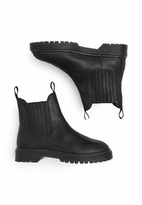 Botas Chelsea de cuero negro con paneles elásticos, acentos texturizados, tiradores y suela de goma resistente con patrones de tacos profundos.