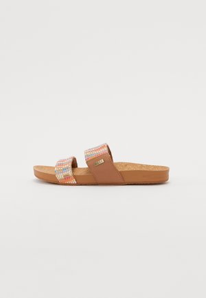 Brun slip-in sandal med korksål og to flerfarvede vævede stofstropper, hvoraf den ene har et lille mærke i metal.
