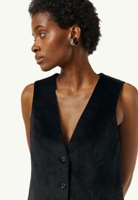 Schwarze ärmellose Weste mit tiefem V-Ausschnitt, aus weichem Material gefertigt, mit zwei vorderen Knöpfen und einer glatten Textur. Schlichtes, elegantes Design.