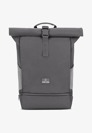 Zaino grigio a rullo con chiusura a fibbia, materiale tessile, forma strutturata, tasche laterali e una discreta etichetta con logo sul fronte.