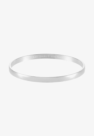 Hopeakosketin metallinen rannekoru, pyöreä muoto ja sileä, kiillotettu pinta. Kaiverrettu logo sisäpuolella. Minimalistinen muotoilu.
