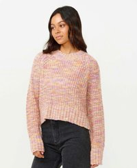 Sweter robiony na szydełku w pastelowych różowych i pomarańczowych odcieniach, z prążkowanym dekoltem i mankietami, w kroju krótkim, w połączeniu z ciemnymi dżinsami.