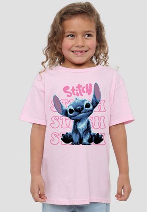 Rosa Baumwoll-T-Shirt mit der Cartoonfigur Stitch, der große Ohren hat und in Sitzposition dargestellt ist, samt dem Wort "Stitch" in stilisierter Schrift.