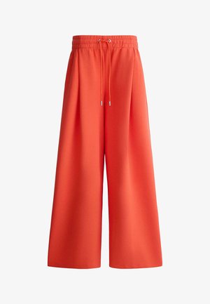 Weit geschnittene orangefarbene Hose mit elastischem Bund und Kordelzug, aus glattem Stoff gefertigt, für eine lockere, bequeme Passform entworfen.