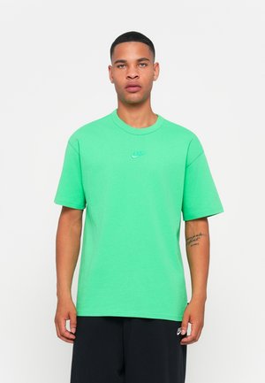 Grøn bomulds T-shirt med rund halsudskæring og et lille Nike-logo på brystet. Korte ærmer og en afslappet pasform.
