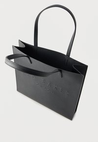 Μαύρη υφή τσάντα ώμου με ανάγλυφο λογότυπο στο μπροστινό μέρος και μακριές λαβές για εύκολη μεταφορά. Σχεδιασμός με ανοιχτή κορυφή και ελάχιστη δομή.