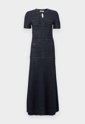 Robe maxi en maille bleu marine à manches courtes, fermeture boutonnée à l'avant, petit col en trou de serrure, et détails texturés des poches sur la poitrine et les hanches.