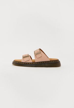 Pink lædersandal med to justerbare spænderem, brun polstret indersål og tyk sort sål med gul syning.