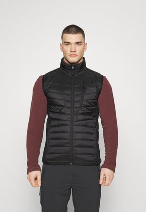Sort, puffet vest med lynlås foran, høj krave og horisontale kviltede mønstre. Bæres over en mørkerød langærmet skjorte. Holdbart stof.