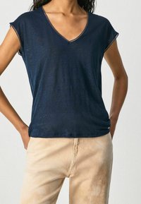 Námorně modré, krátké rukávy, tričko s V výstřihem vyrobené z lehkého materiálu s volným střihem a krajkovými detaily kolem výstřihu a rukávů.
