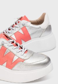 Stříbrné syntetické tenisky s texturovaným povrchem, s výraznými korálovými doplňky a tlustou bílou podrážkou. Šněrování s výrazným značením.