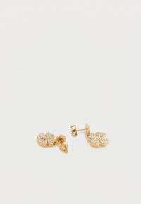 Σκουλαρίκια καρφάκια σε χρυσή απόχρωση, σε σχήμα λουλουδιού, διακοσμημένα με διαφανείς στρας. Διαθέτουν ασφαλές κλείσιμο με πίσω καρφί και υφή στην επιφάνεια.