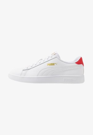 Biały skórzany sneaker Puma z czerwoną zakładką na pięcie, złotym logo Puma po boku, białymi sznurowadłami i białą podeszwą.