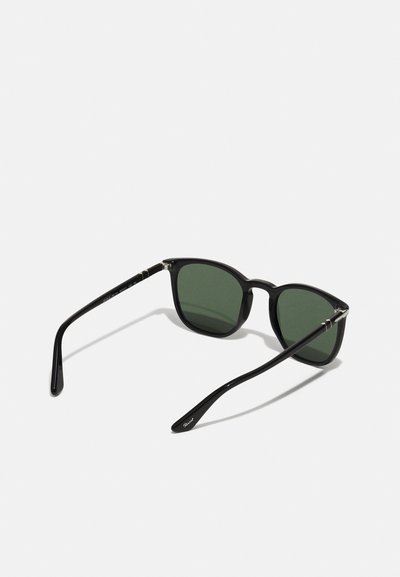 Black sunglasses with green lenses, rectangular shape, thick frame, and sleek arms featuring silver accents.