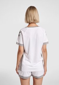 White sports jersey with gray accents and textured fabric, featuring a round neckline and short sleeves, paired with matching shorts.