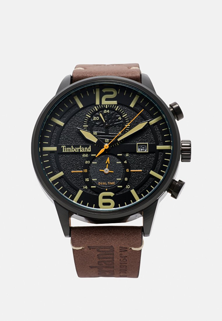 Reloj Timberland negro y dorado con una esfera texturizada, visualización de doble hora, funciones de cronógrafo y una correa de cuero marrón.