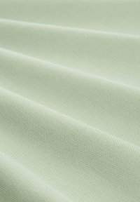 Tela de color verde claro con una superficie texturizada, que muestra pliegues y un patrón tejido suave, adecuada para diversas aplicaciones textiles.