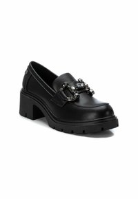 Mocasines de charol negros con tacón cuadrado que presentan una suela gruesa, una tira decorativa con piedras preciosas y un acabado suave. Diseño de fácil puesta.