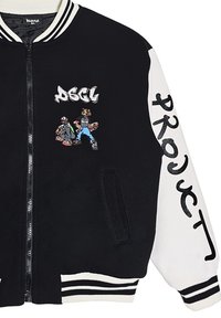 Giacca varsity bianca e nera con logo DSCL ricamato e grafiche di cartoni animati, dotata di zip frontale, polsini a coste e tasche laterali.