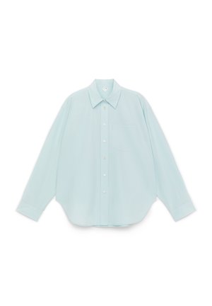 Jasnoniebieska koszula zapinana na guziki z kołnierzem typu spread, długimi rękawami, pojedynczą kieszenią na piersi i zaokrąglonym dołem. Gładka faktura tkaniny.