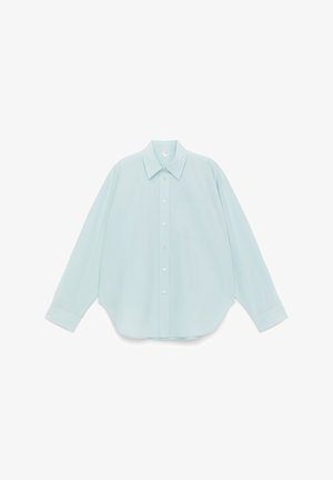 Jasnoniebieska koszula zapinana na guziki z kołnierzem typu spread, długimi rękawami, pojedynczą kieszenią na piersi i zaokrąglonym dołem. Gładka faktura tkaniny.