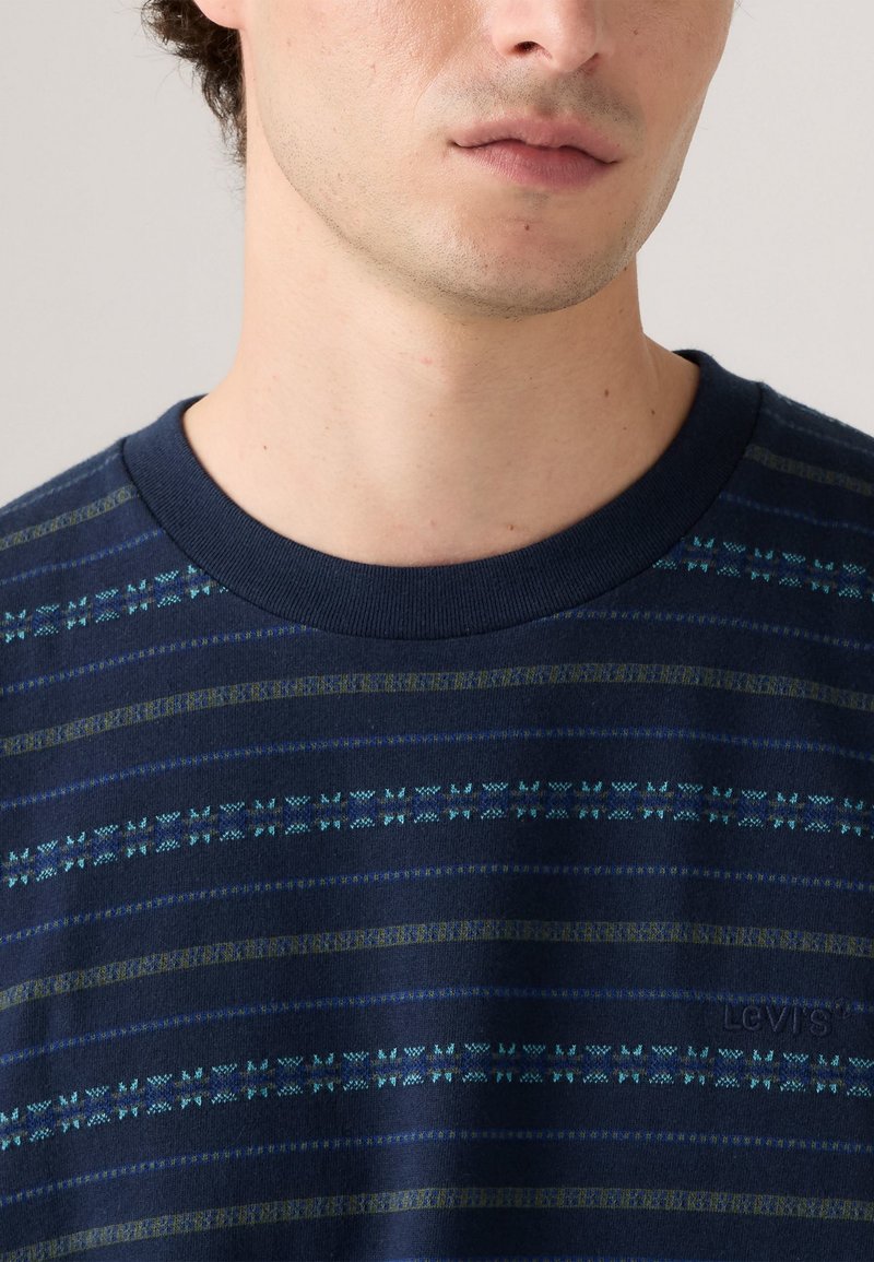 Camicia a maniche corte blu navy con strisce orizzontali in varie tonalità di blu e verde, caratterizzata da un colletto a costine e un logo discreto.