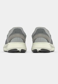 Pilki sportiniai bateliai su tinkline ir zomšinė medžiaga, suapvalinta forma, paminkštintu padu ir kontrastingais šviesiais padu.