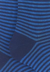 Calze a righe blu e navy con una finitura testurizzata. Presenta righe orizzontali e un'area della punta rinforzata. Il tessuto sembra morbido ed elastico.