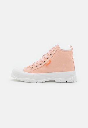 Jasnoróżowy płócienny tenisówka za kostkę z grubą białą gumową podeszwą i pomarańczową metką "Refresh" po boku, sfotografowana na białym tle.