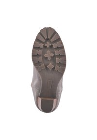 Bota marrón con suela de tracción robusta, que presenta patrones de tracción en forma de estrella y un ligero tacón. Parte superior de cuero liso con acentos contrastantes.