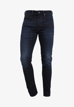 Dunkelblaue Jeans aus Denim mit schlankem Schnitt, ausgestattet mit fünf Taschen, einem Knopf- und Reißverschluss sowie einem dezenten Verblassen an den Oberschenkeln.