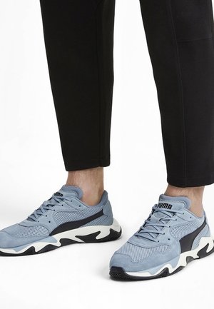 Jasnoniebieskie sportowe sneakersy z czarnym akcentem, siateczkową cholewką i białą podeszwą. Posiadają sznurowanie i logo Pumy.