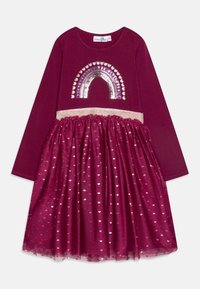 Bordowa sukienka z długimi rękawami, z wzorem tęczy z cekinów i brokatowym pasem w talii. Warstwowa spódnica ma przezroczysty materiał z serduszkowymi wzorami.