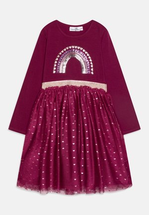 Abito bordeaux con maniche lunghe, caratterizzato da un design arcobaleno di paillettes e una vita glitterata. La gonna a strati presenta un tessuto trasparente con motivi a cuore.