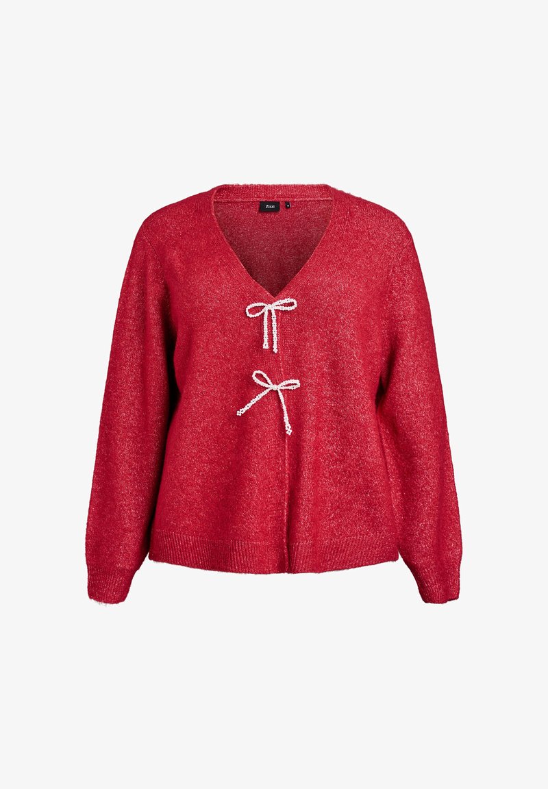 Raudona, blizgi mezgimo megztinis su V formos iškirpte ir dviem dekoratyvinėmis baltosiomis juostelėmis centre. Ilgos rankovės ir nertų hemų detalė.