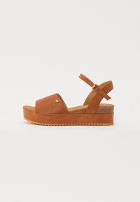 Brune plattform sandaler med en teksturert stropp, åpen tå og justerbar ankelrem. Laget av semsket skinn med gummisåle.