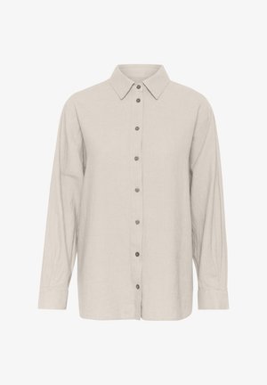 Svetlo béžová dlhá košeľa s dlhým rukávom vyrobená z ľanu, s klasickým golierom, gombíkovým zapínaním a voľným strihom s gombíkovými manžetami.