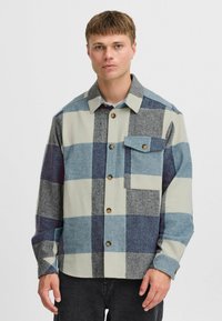 Herren-Multikolorjacke in Blau, Grau und Creme; mit Knopfverschluss, Brusttasche und Kragen. Weicher, strukturierter Stoff.