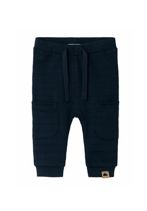 Joggers en tricot bleu marine avec deux poches latérales, taille et poignets côtelés, présentant un motif rayé texturé et un petit écusson logo.