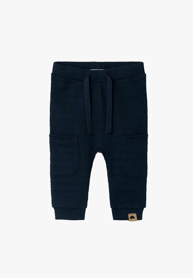 Joggers en tricot bleu marine avec deux poches latérales, taille et poignets côtelés, présentant un motif rayé texturé et un petit écusson logo.