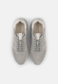 Lys grå semsket skinn sneakers med teksturerte overlegg, grå snøringer og en hvit tunge label. Har en polstret krage og gummisåle.