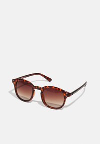 Schildkrötenmuster Sonnenbrille mit dunkelbraunen Verlaufslinsen, runder Form und schwarzen Tempelakzenten; verfügt über zwei kleine Metallschrauben in der Nähe der Linsen.
