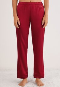 Rode, lichte polyester pyjamabroek met een elastische tailleband en rechte pijpen, met een opgerold manchet detail aan de onderkant.