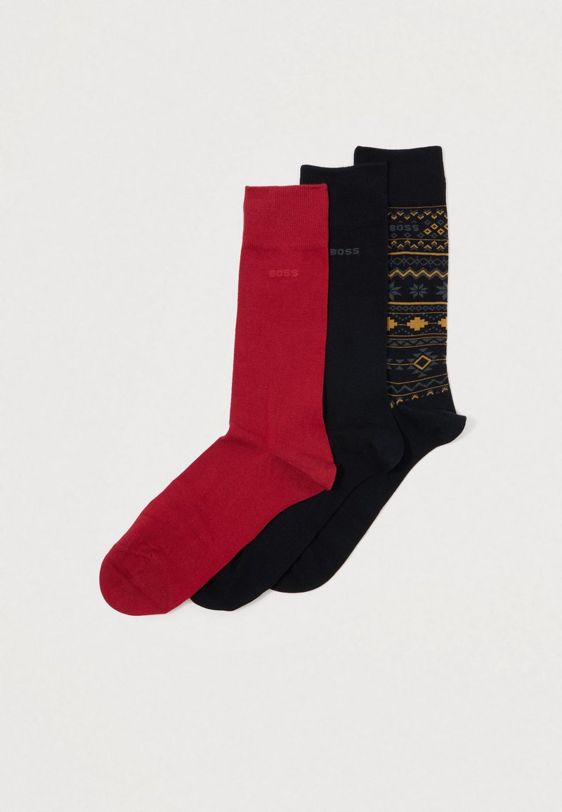 Drei Paar Socken: ein rotes, ein einfarbig schwarzes und eines mit schwarzen Geometrien in Gelb und Blau gemustert. Hergestellt aus glattem Stoff.